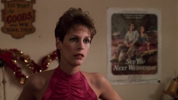Movie still from “Trading Places” (1983), directed by John Landis – A woman in a red dress standing in front of a movie poster; Close Up shot, Low angle