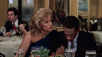 Movie still from “Trading Places” (1983), directed by John Landis – A man and a woman sitting at a dinner table; Close Up shot, Over the shoulder angle