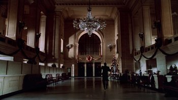 Movie still from “Trading Places” (1983), directed by John Landis – A man walking in a large room with a christmas tree; Extreme Wide shot, Low angle