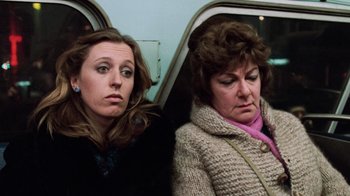 Movie still from “Trading Places” (1983), directed by John Landis – Two women sitting next to each other on a train; Close Up shot, High angle