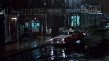 Movie still from “Trading Places” (1983), directed by John Landis – A car parked on the side of the road in the rain; Extreme Wide shot, High angle