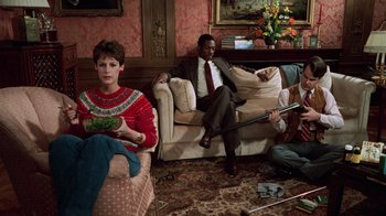 Movie still from “Trading Places” (1983), directed by John Landis – A man and a woman sitting in a living room next to each other; Wide shot, High angle