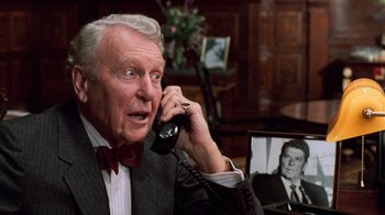 Movie still from “Trading Places” (1983), directed by John Landis – An older man talking on the phone with an older man in the background; Close Up shot, Over the shoulder angle