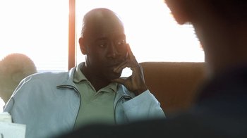 Movie still from “Traffic” (2000), directed by Steven Soderbergh – A person talking on a cell phone; Medium shot, Over the shoulder angle