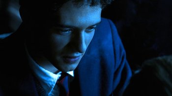 Movie still from “Traffic” (2000), directed by Steven Soderbergh – A man in a suit and tie looking at the camera; Close Up shot, Low angle