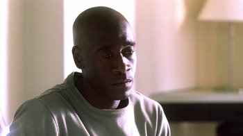 Movie still from “Traffic” (2000), directed by Steven Soderbergh – A man with a bald head sitting in front of a window; Close Up shot, High angle
