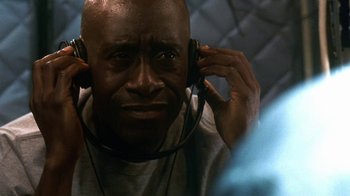 Movie still from “Traffic” (2000), directed by Steven Soderbergh – A man wearing headphones and holding his head down; Close Up shot, Low angle