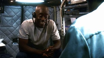 Movie still from “Traffic” (2000), directed by Steven Soderbergh – A man wearing headphones and sitting in a chair; Close Up shot, Low angle