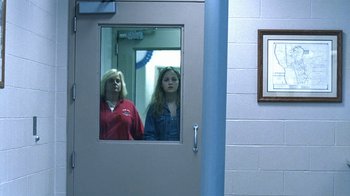 Movie still from “Traffic” (2000), directed by Steven Soderbergh – Two women are standing in a room looking in a mirror; Medium shot, Low angle