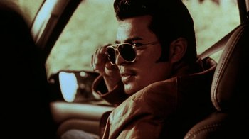 Movie still from “Traffic” (2000), directed by Steven Soderbergh – A man with sunglasses sitting in the driver's seat of a car; Close Up shot, Low angle