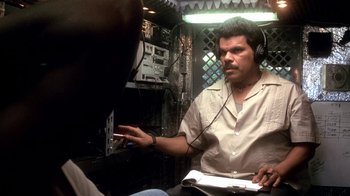 Movie still from “Traffic” (2000), directed by Steven Soderbergh – A man with a headset is sitting in front of a radio; Medium shot, Low angle