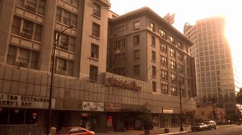 Movie still from “Traffic” (2000), directed by Steven Soderbergh – A large building with many windows on a city street; Extreme Wide shot, Low angle