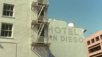 Movie still from “Traffic” (2000), directed by Steven Soderbergh – A fire escape on the side of a building in san diego; Extreme Wide shot, Low angle