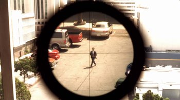 Movie still from “Traffic” (2000), directed by Steven Soderbergh – A man in a suit is seen through a rifle scope; Extreme Wide shot, High angle