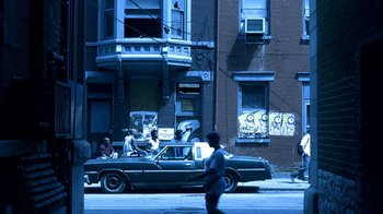 Movie still from “Traffic” (2000), directed by Steven Soderbergh – A man walking down the street in front of an old car; Extreme Wide shot, High angle
