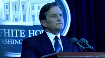 Movie still from “Traffic” (2000), directed by Steven Soderbergh – A person speaking at a podium; Close Up shot, Low angle