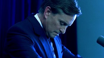 Movie still from “Traffic” (2000), directed by Steven Soderbergh – A person wearing a suit and tie; Close Up shot, Low angle