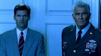 Movie still from “Traffic” (2000), directed by Steven Soderbergh – Two men standing next to each other in front of a door; Medium shot, Low angle