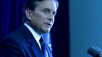 Movie still from “Traffic” (2000), directed by Steven Soderbergh – A person wearing a suit and tie; Close Up shot, Over the shoulder angle