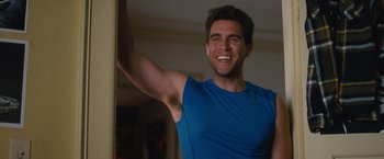 Movie still from “Trainwreck” (2015), directed by Judd Apatow – A man in a blue t - shirt is smiling; Close Up shot, Over the shoulder angle