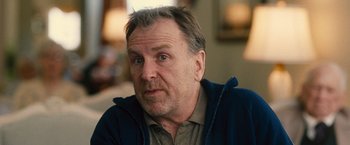 Movie still from “Trainwreck” (2015), directed by Judd Apatow – An older man is looking at the camera; Close Up shot, Over the shoulder angle