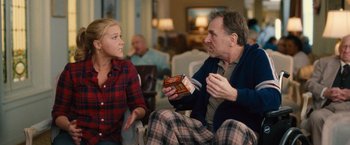 Movie still from “Trainwreck” (2015), directed by Judd Apatow – A man and a woman sitting in a living room talking; Medium shot, Over the shoulder angle