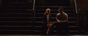 Movie still from “Trainwreck” (2015), directed by Judd Apatow – A man and a woman sitting on some steps; Wide shot, High angle