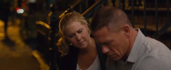 Movie still from “Trainwreck” (2015), directed by Judd Apatow – A woman and a man sitting next to each other on stairs; Close Up shot, High angle