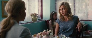 Movie still from “Trainwreck” (2015), directed by Judd Apatow – A woman sitting at a table with a plate of food; Medium shot, Over the shoulder angle