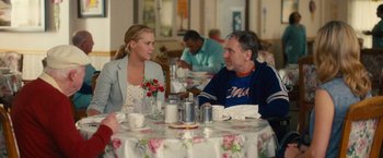 Movie still from “Trainwreck” (2015), directed by Judd Apatow – A man and a woman are sitting at a table; Medium shot, Over the shoulder angle