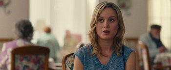 Movie still from “Trainwreck” (2015), directed by Judd Apatow – A woman sitting at a table looking at the camera; Close Up shot, Over the shoulder angle