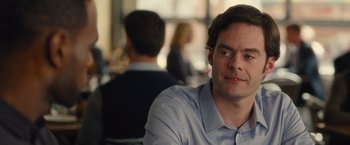 Movie still from “Trainwreck” (2015), directed by Judd Apatow – A person sitting at a table in front of other people; Close Up shot, Over the shoulder angle