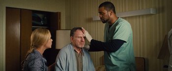 Movie still from “Trainwreck” (2015), directed by Judd Apatow – A man is getting his head examined by a doctor; Medium shot, Over the shoulder angle