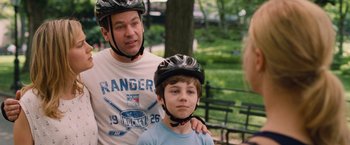 Movie still from “Trainwreck” (2015), directed by Judd Apatow – A man and a boy wearing helmets and standing next to each other; Medium shot, Over the shoulder angle