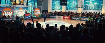 Movie still from “Trainwreck” (2015), directed by Judd Apatow – A crowd of people are watching a basketball game in front of an audience; Extreme Wide shot, High angle