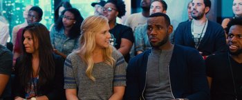 Movie still from “Trainwreck” (2015), directed by Judd Apatow – A couple of people that are sitting next to each other; Close Up shot, Over the shoulder angle