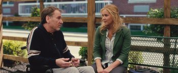 Movie still from “Trainwreck” (2015), directed by Judd Apatow – A man and a woman are sitting on a bench; Medium shot, Over the shoulder angle
