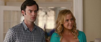 Movie still from “Trainwreck” (2015), directed by Judd Apatow – A man and a woman standing next to each other in a room; Close Up shot, Over the shoulder angle