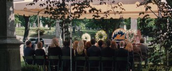 Movie still from “Trainwreck” (2015), directed by Judd Apatow – A group of people sitting in chairs at a funeral; Wide shot, Over the shoulder angle