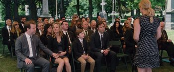 Movie still from “Trainwreck” (2015), directed by Judd Apatow – A group of people in suits and ties at a funeral; Wide shot, High angle