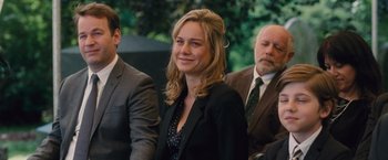 Movie still from “Trainwreck” (2015), directed by Judd Apatow – A woman in a black jacket is smiling for the camera; Medium shot, Over the shoulder angle