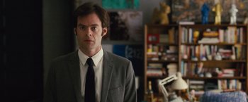 Movie still from “Trainwreck” (2015), directed by Judd Apatow – A man wearing a suit and tie standing in a room; Close Up shot, Over the shoulder angle