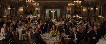Movie still from “Trainwreck” (2015), directed by Judd Apatow – A group of people sitting around a table at a formal event; Wide shot, High angle