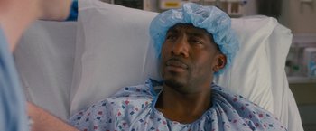 Movie still from “Trainwreck” (2015), directed by Judd Apatow – A man in a hospital bed wearing a surgical cap; Close Up shot, High angle
