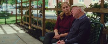 Movie still from “Trainwreck” (2015), directed by Judd Apatow – An older man sitting next to a young woman; Medium shot, Over the shoulder angle
