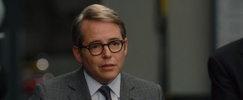 Movie still from “Trainwreck” (2015), directed by Judd Apatow – A person wearing glasses and a suit; Close Up shot, Over the shoulder angle