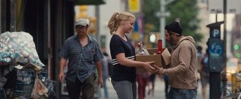 Movie still from “Trainwreck” (2015), directed by Judd Apatow – A woman handing a box to a man on the street; Medium shot, Over the shoulder angle