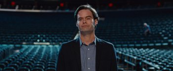 Movie still from “Trainwreck” (2015), directed by Judd Apatow – A man in a suit standing in front of an audience; Close Up shot, Low angle