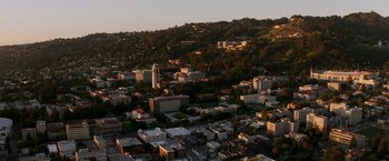 Movie still from “Transcendence” (2014), directed by Wally Pfister – An aerial view of a large city with buildings on top of a hill; Extreme Wide shot, High angle