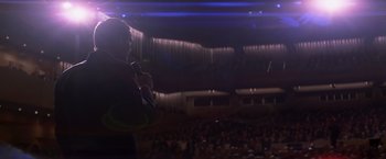 Movie still from “Transcendence” (2014), directed by Wally Pfister – A man standing in front of an audience holding a microphone; Medium shot, Low angle